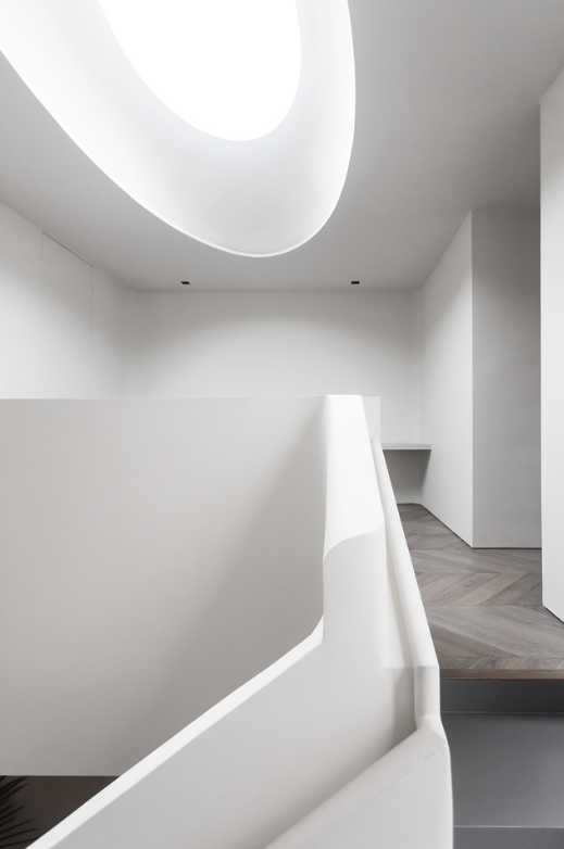 Stair landing beneath an oval skylight