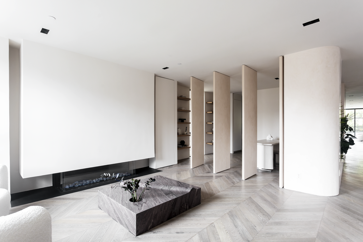 Living space with sculpted fireplace and pivoting panels